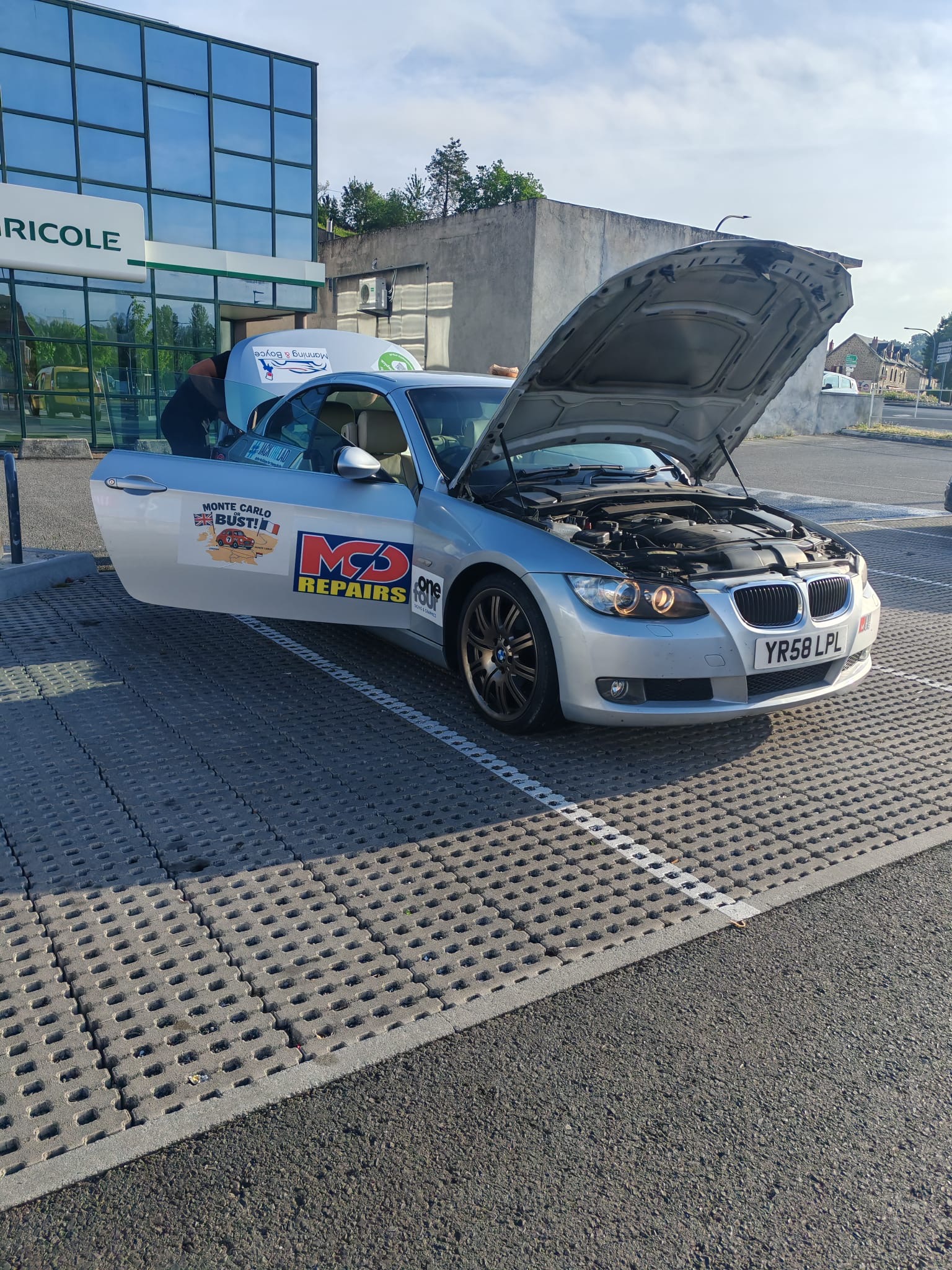 BMW rally car with its bonnet open during the previous trip